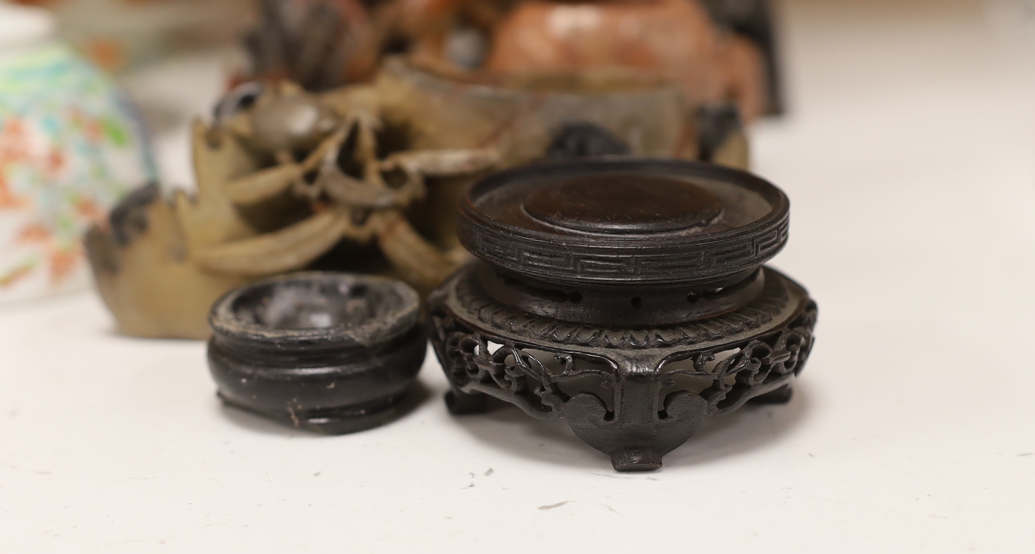 Two Japanese tea bowls one with cover and saucer, a saucer and cover, two Chinese soapstone carvings and four stands